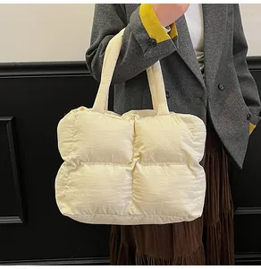 Detail of creamy white quilted down tote bag with a soft puffy texture and large capacity