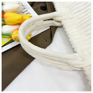 Détail de la poignée du sac cabas en velours côtelé blanc avec texture douce et coutures