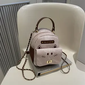 Mini pink cat-shaped backpack with gold chain strap and cute embroidered cat face details