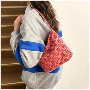 Detail of red Chinese wedding tote bag featuring knitted double happiness motif on shoulder