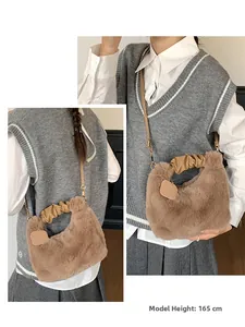 Detail of plush brown faux fur handbag with gold hardware on 165cm model height