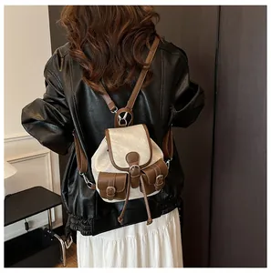 Détail du mini sac à dos vintage en toile crème avec des lanières en cuir marron