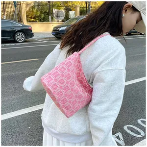 Pink shoulder bag with red double happiness jacquard embroidery in an outdoor street setting