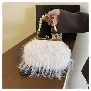 Dettaglio della borsa a tracolla in peluche bianca con manico di perle e chiusura in metallo