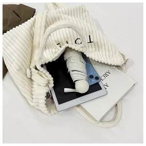 Vue de dessus du sac cabas en velours côtelé crème avec tablette et parapluie à l'intérieur