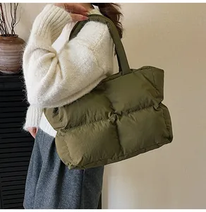 Detail view of the olive green quilted tote bag showing texture and side capacity
