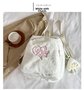 Détail du sac à dos en peluche blanche avec broderie cœur rose et charm mignon