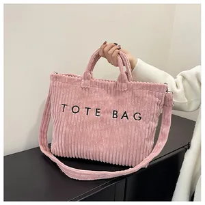Détail du sac cabas en velours côtelé rose avec broderie et bandoulière polyvalente