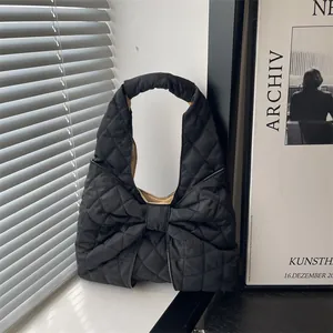 Large black quilted tote bag with bow detail and nylon finish for women