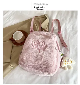 Détail du sac à dos en peluche rose avec broderie coeur et petit pendentif blanc mignon