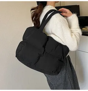 Model view of a large black quilted tote bag for women showing the soft texture and size