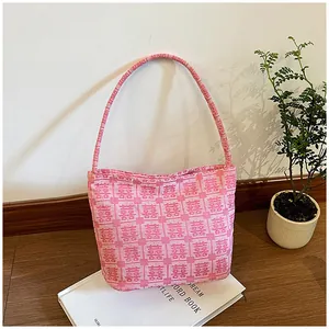Close-up of pink tote bag with red Double Happiness embroidery on a white book