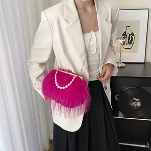 Borsa a tracolla fucsia piumata con manico di perle e catena dorata elegante