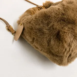 Close-up detail of plush khaki handbag showing soft faux fur texture and leather strap