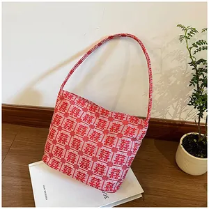 Detailed view of Chinese wedding tote bag with red and white Xi character jacquard pattern