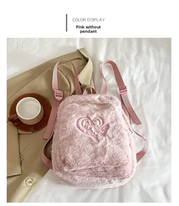 Détail d'un sac à dos rose en peluche avec broderie de cœur sur tissu moelleux