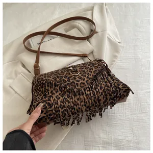 Close-up of leopard print shoulder bag featuring long fringe and a gold metal ring buckle