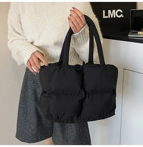 Close-up of black quilted puffer tote bag styled with a minimalist autumn outfit