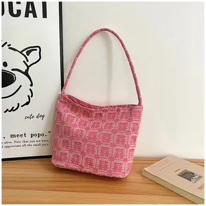 Detail of pink woven tote bag featuring red double happiness patterns on a wooden table
