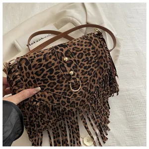 Detail of leopard print crossbody bag with long fringes and gold rivet accents