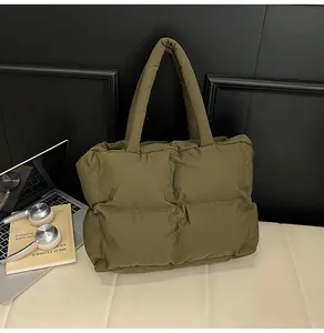 Detail showing high-quality olive green quilted down tote bag with a glossy finish
