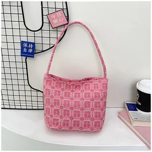 Detail of pink bridal tote bag with woven Xi wedding patterns in a lifestyle setting