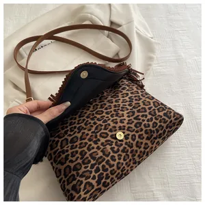 Detail of leopard print crossbody bag featuring vintage fringe edges and magnetic clasp