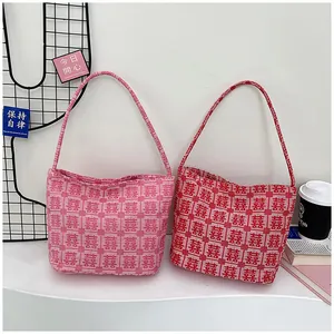 Detail of red and pink bridal tote bags featuring traditional Chinese wedding patterns
