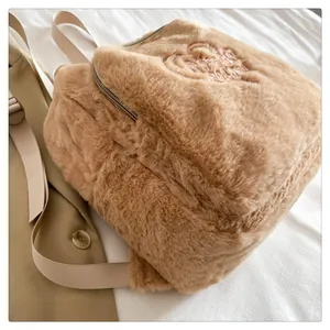 Dettaglio zaino in pelliccia sintetica marrone con ricamo rosa e spalline regolabili