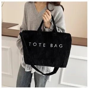 Détail du sac cabas en velours côtelé noir avec broderie blanche et texture douce