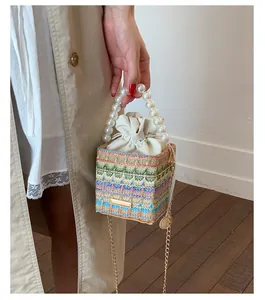 Détail du sac seau tissé avec poignée en perles et motifs géométriques colorés