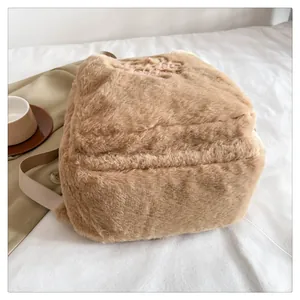 Dettaglio dello zaino in peluche con logo ricamato e ampia tracolla in tessuto morbido