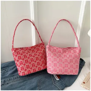 Detailed close-up of red and pink knitted tote bags featuring traditional Xi patterns
