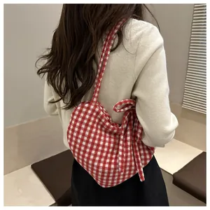 Detail van hartvormige rode gingham canvas schoudertas met decoratieve zijlinten