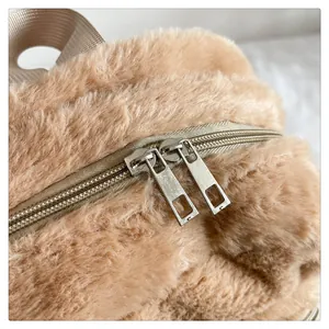 Dettaglio dello zaino in peluche con doppia zip argentata e manico in nylon marrone