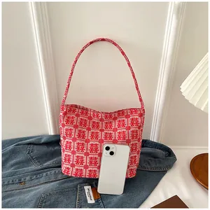 Detail of red and white woven tote bag with Double Happiness pattern on denim jacket