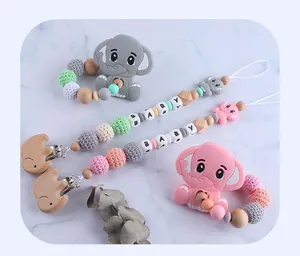 Detail view of silicone elephant teether set with beech wood pacifier clip on marble