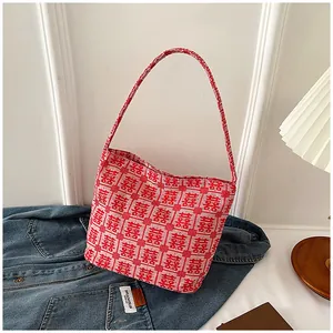 Detail of red bridal tote bag featuring woven Xi character and sturdy shoulder strap