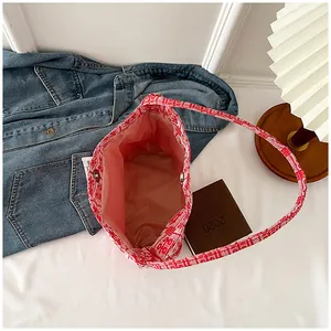 Detail view of red floral canvas tote bag featuring magnetic clasp and spacious interior