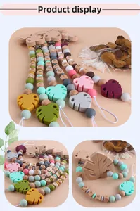 Detail of baby pacifier clips featuring beech wood beads and silicone monstera leaves