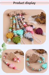 Macro detail of silicone beads and wooden leaf pendant on a handmade baby pacifier clip