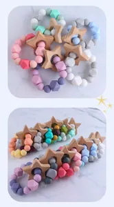 Detailed macro of baby teething ring with colorful silicone beads and beech wood star charm