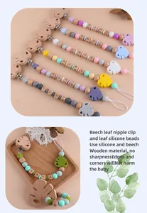 Detail of baby pacifier clip with beech wood leaves and colorful silicone beads