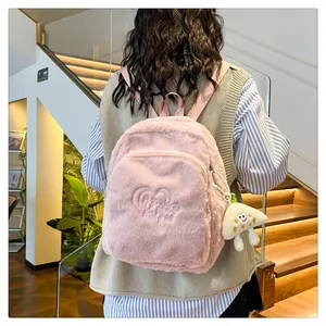 Zaino in peluche rosa con ricamo a cuore e ciondolo a fungo visto dal retro