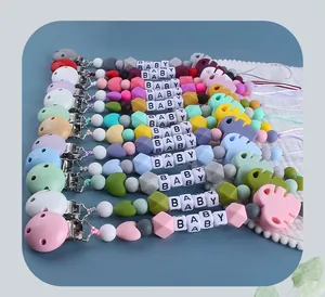 Detailed arrangement of silicone pacifier clips with colorful beads and monstera leaves