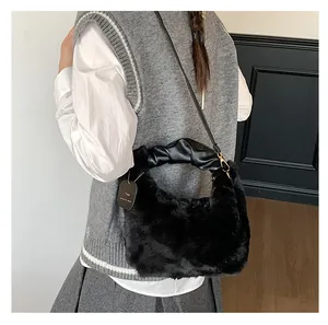 Detail einer schwarzen Kunstpelz-Handtasche mit Falten-PU-Griff und Goldbeschlägen