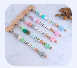 Detail of DIY beechwood elephant pacifier clips with colorful silicone and BABY letter beads