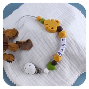 Silicone baby pacifier clip with yellow leaf beads and BABY letters on white cloth