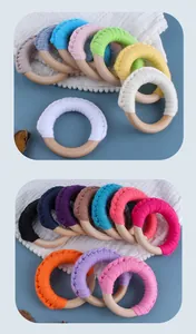 Close-up of handmade colorful cotton rope woven rings on natural smooth wooden ringer teether