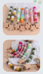 Detail of handmade crochet cotton beads and beech wood star pacifier clip in pastel tones